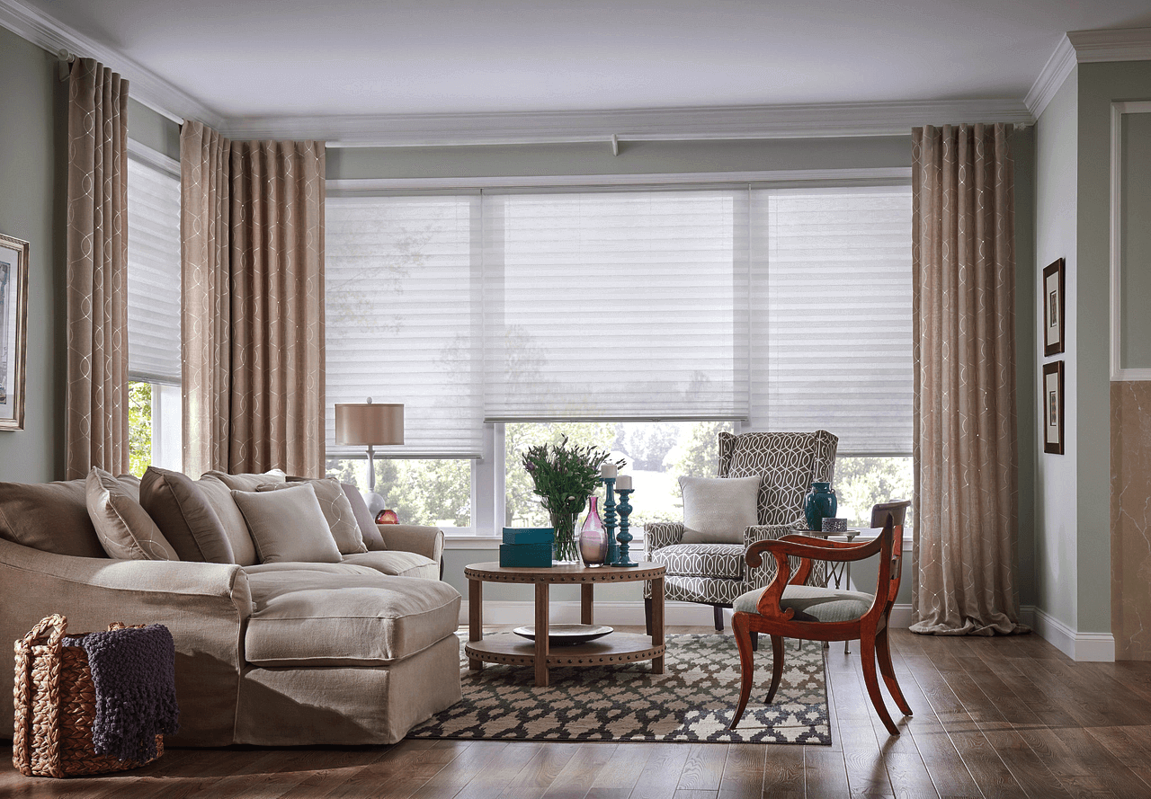 Living room with cellular shades and beautiful floor to ceiling beige drapes San Antonio